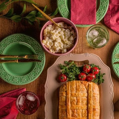 Mesa posta com empadão e acompanhamentos, pronta para uma celebração